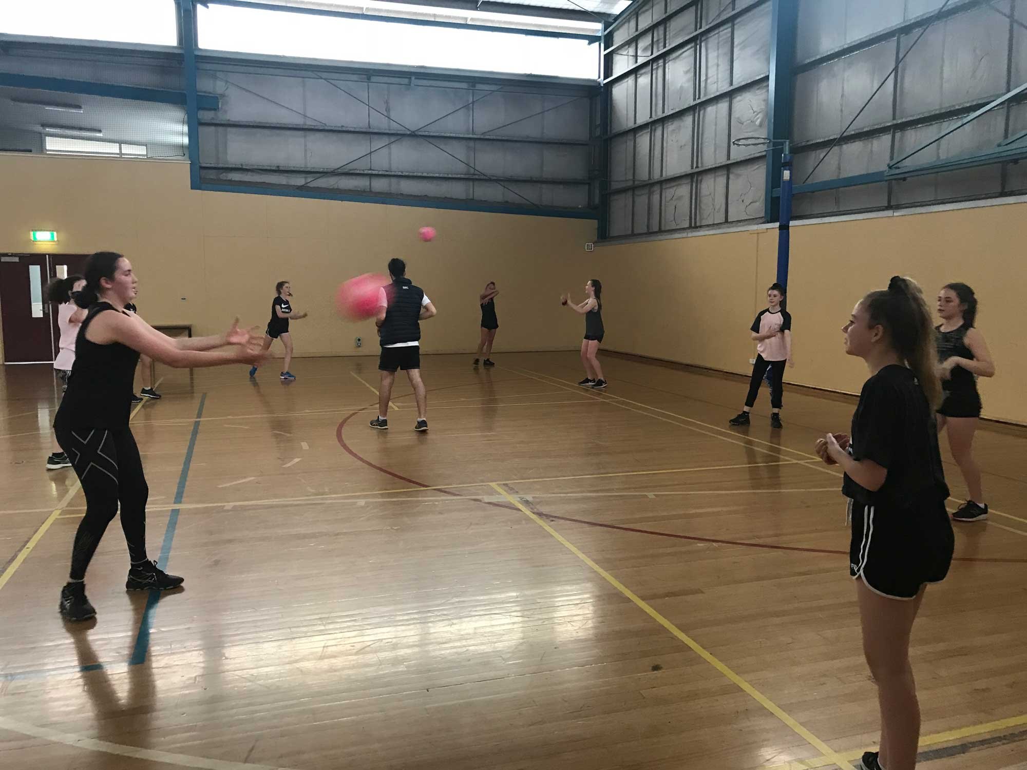 Jaguars players passing at an indoor training night